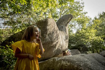 Fille devant un bloc de granit du Sidobre